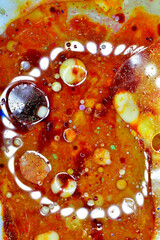 Vertical image of transparent air bubbles on a brown liquid background.