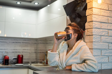 beautiful young girl in home clothes with a black mask resting at home.