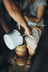 Woman making butter with butter churn. Old traditional method making of butter
