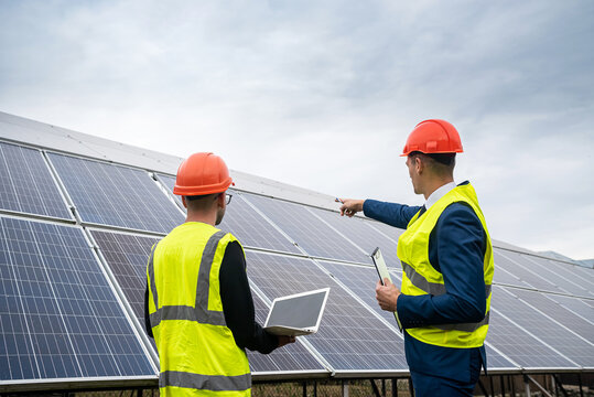 the director of company inspects the work of an employee in  clothing installed solar panels.