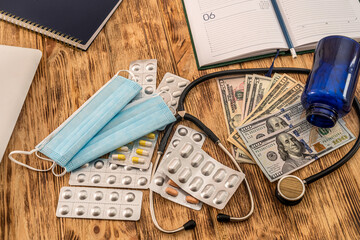 pills with dollar bills stethoscope syringe arranged on a new table