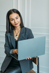 young Asian girl business style clothes, with a laptop