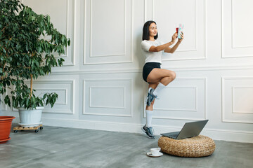 a young Asian girl is broadcasting from home. fitness classes