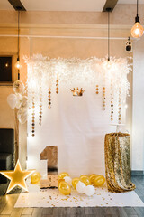 Decor with white and gold balloons for birthday party. Decorations for the first birthday with a star and glitters. Celebration. Playroom.