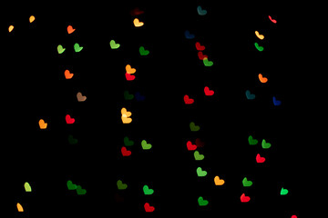 Fototapeta na wymiar Bokeh red, green and yellow lights isolated on black background. Heart-shaped, love concept, Valentine's Day, February 14