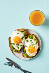 Healthy breakfast with eggs toast and orange juice on blue background