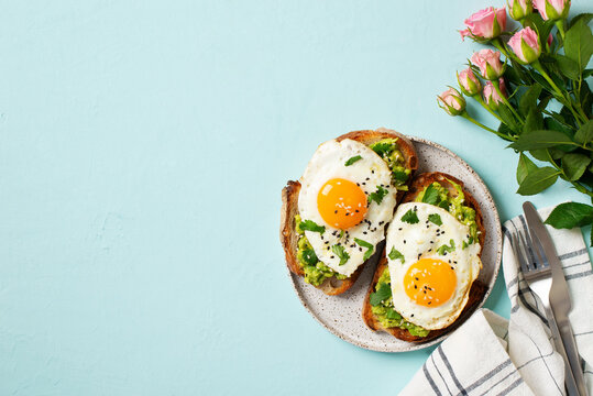 Healthy breakfast with eggs toast and orange juice on blue background