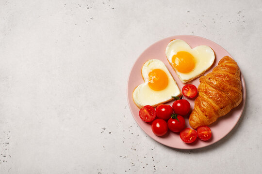 Healthy breakfast with eggs hearts and cup of coffee on grey background