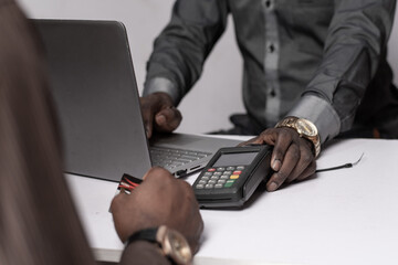 african businessman offers a pos device for payment