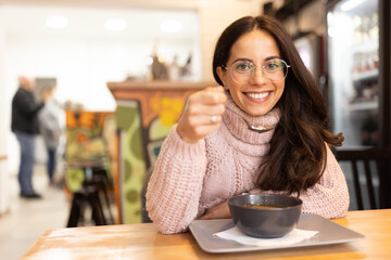 Portrait of cheerful caucasian woman, excited about the taste of her food.