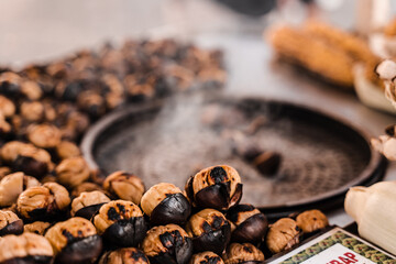 Process of roasting chestnuts on pan. Grilled chestnut snack food on the street market