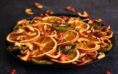 dried slices of orange, lemon, kiwi, apples on a dark background