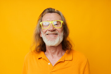 Senior grey-haired man in yellow glasses with a gray beard emotions isolated background