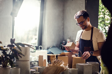 Portrait of craftsman working in his workshop making decorative concrete vase.