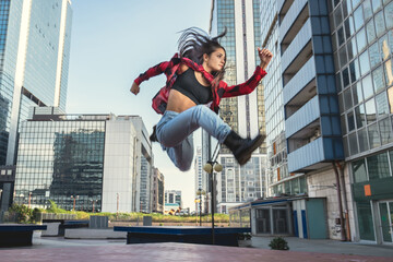 Photo shoot of stylish caucasian hip hop dancer posing jumping with red shirt, jeans and black...