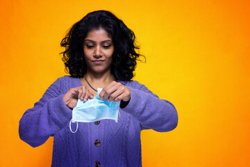 Beautiful young indian woman tears her covid 19 mask protection - Pretty Sri Lanka girl happy for...