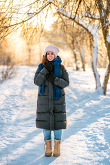 Fototapeta na wymiar A young beautiful woman walks on a path in a snowy winter forest
