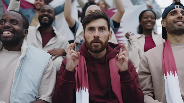 Man crossing fingers while supporting football team