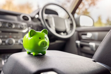 Green piggy bank money box inside car, vehicle purchase, insurance or driving and motoring cost - 480913482