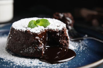 Delicious fresh fondant with hot chocolate and mint on plate, closeup