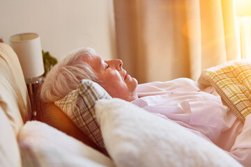 Alte Frau beim Schlafen im Bett vom Altersheim