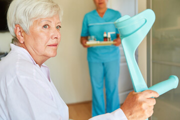 Nachdenkliche Seniorin mit Krücken nach Schlaganfall