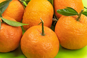 several isolated clementines on a green background