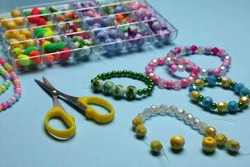 Composition with different colorful beads on light blue background