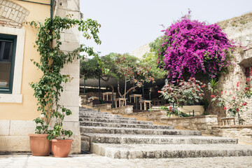 Fototapeta na wymiar Corfu town picturesque street with cafe and flowers, Corfu island, Ionian islands, Greece.
