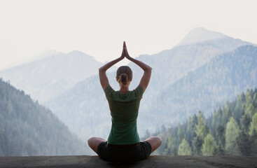 Young woman practicing yoga in mountains at sunset. Harmony, meditation, healthy lifestyle, relaxation, yoga, self care, mindfulness concept