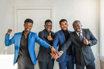 successful african people in suits holding hands together 