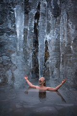 Mann im kalten Bad der Eishöhle