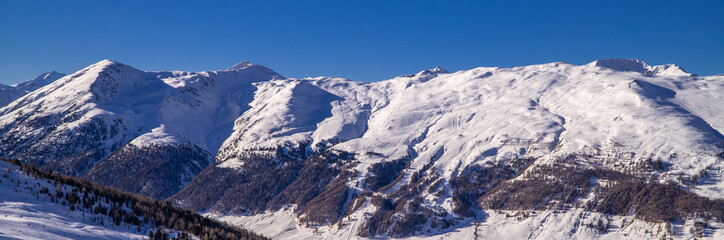 Fototapeta na wymiar Stunning alpine panorama view of snowy peaks near the Italian ski resort town of Livigno