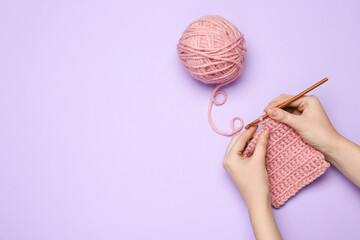 Woman crocheting with pink thread on violet background, top view. Space for text - obrazy, fototapety, plakaty