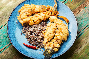 Fried sea bass with wild rice.