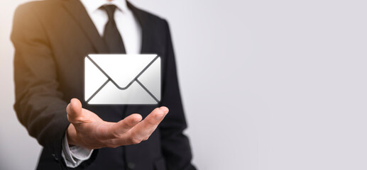 Businessman hand holding e-mail icon, Contact us by newsletter email and protect your personal...