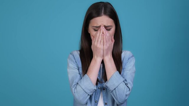 Lady close hands mouth feel disappointed isolated blue color background