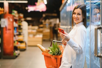 Woman grocery shopping and looking very happy
