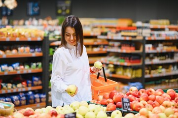 Woman grocery shopping and looking very happy