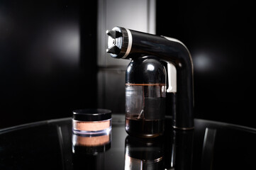 A close-up of the instant tanning equipment. Gun spraying paint for leather and matting body powder...