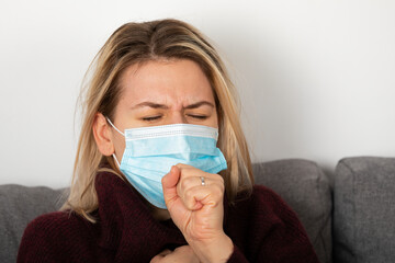 Sick woman with protective mask at home