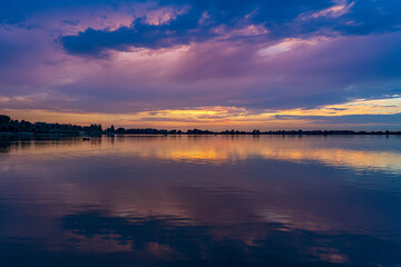 On this almost windless evening the last boats sail back to the harbor and the just set sun creates beautiful colors in the sky