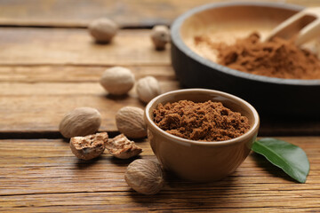 Ground nutmeg and scattered whole seeds on wooden table