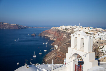 Fototapeta na wymiar Domes, steeples, bells and white buildings of Santorini, Greece