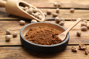 Ground nutmeg and scattered seeds on wooden table