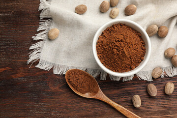 Flat lay composition with nutmeg powder and seeds on wooden table