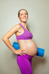 Pregnant woman with big tummy pose hold yoga mate