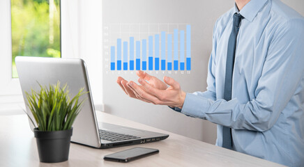 Business man holding tablet and showing holographic graphs and stock market statistics gain profits. Concept of growth planning and business strategy. Display of good economy form digital screen.