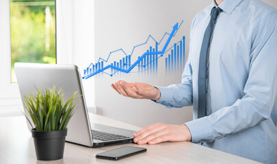 Business man holding tablet and showing holographic graphs and stock market statistics gain profits. Concept of growth planning and business strategy. Display of good economy form digital screen.