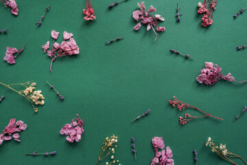 Floral pattern from dried flowers on green.